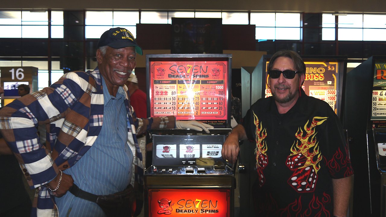 Behind-the-scenes portrait beside a slot-machine prop