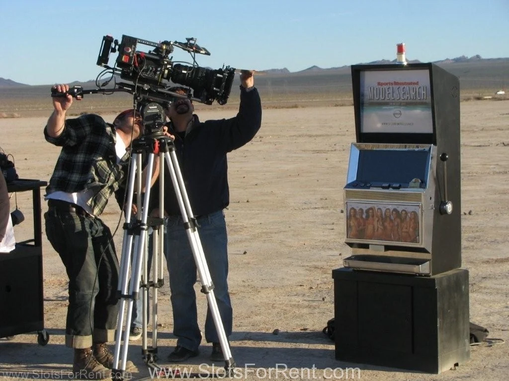 Camera crew filming a slot-machine prop on a desert production set
