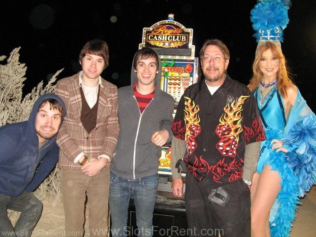 Production team and branded slot-machine prop on a nighttime set